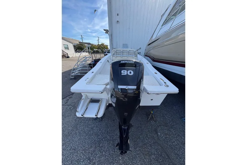 Slide: The Image of 2021 Savannah SS19 boat with Mercury 90 outboard motor, parked outdoors. - 13