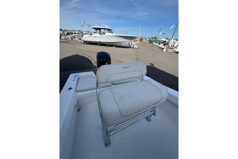 Slide: The Image of 2021 Savannah SS19 boat with white seating, docked at a marina under clear blue skies. - 18