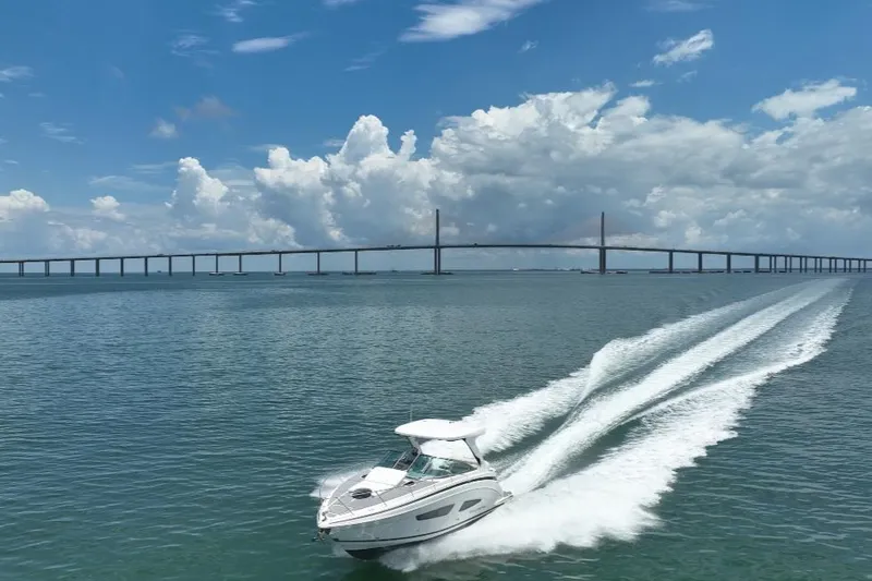 Slide: The Image of 2021 Regal 33 XO boat on calm water under a clear sky. - 1