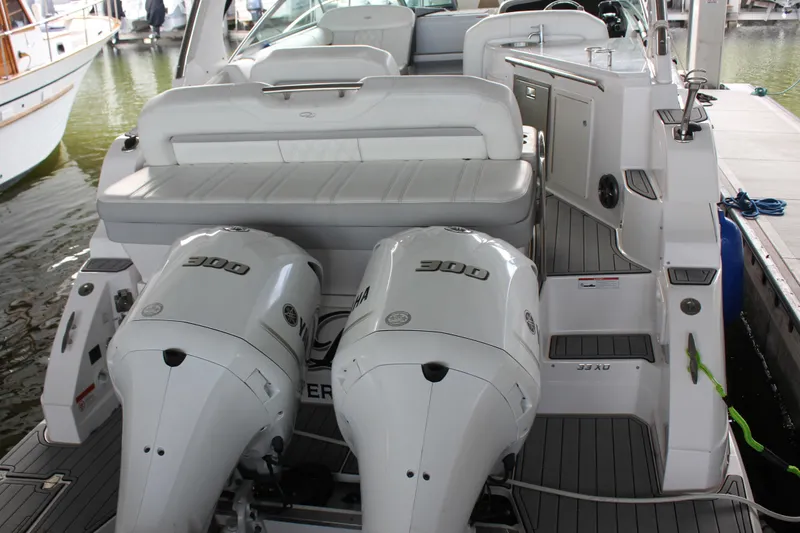 Slide: The Image of 2021 Regal 33 XO boat with dual Yamaha 300 engines, docked in a marina. - 10