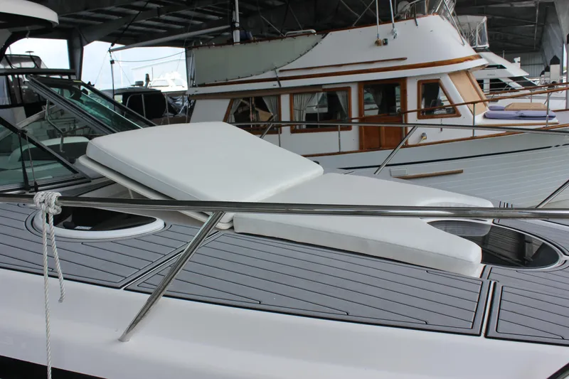 Slide: The Image of 2021 Regal 33 XO yacht with sunbed on deck, docked under shelter. - 12