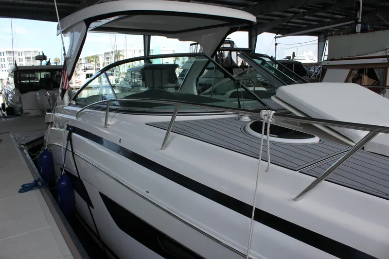 Slide: The Image of 2021 Regal 33 XO yacht docked in marina, sleek design, under covered area. - 13