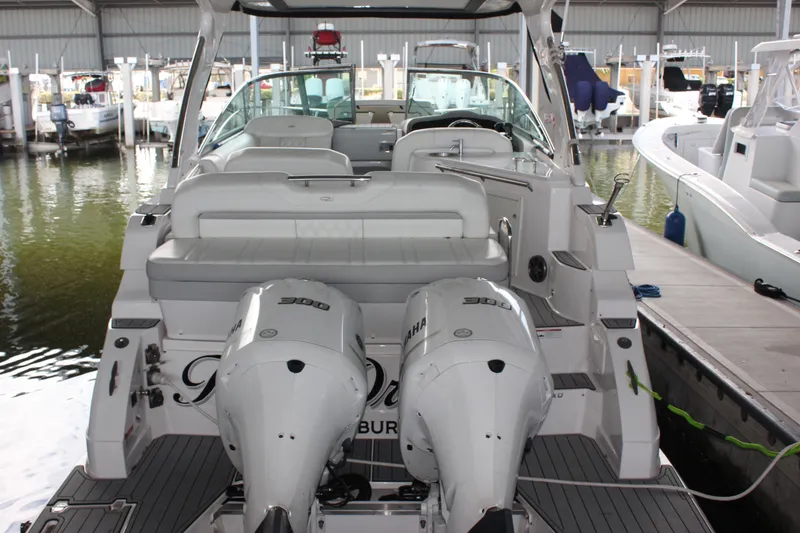 Slide: The Image of 2021 Regal 33 XO boat with dual Yamaha engines docked in a marina. - 17