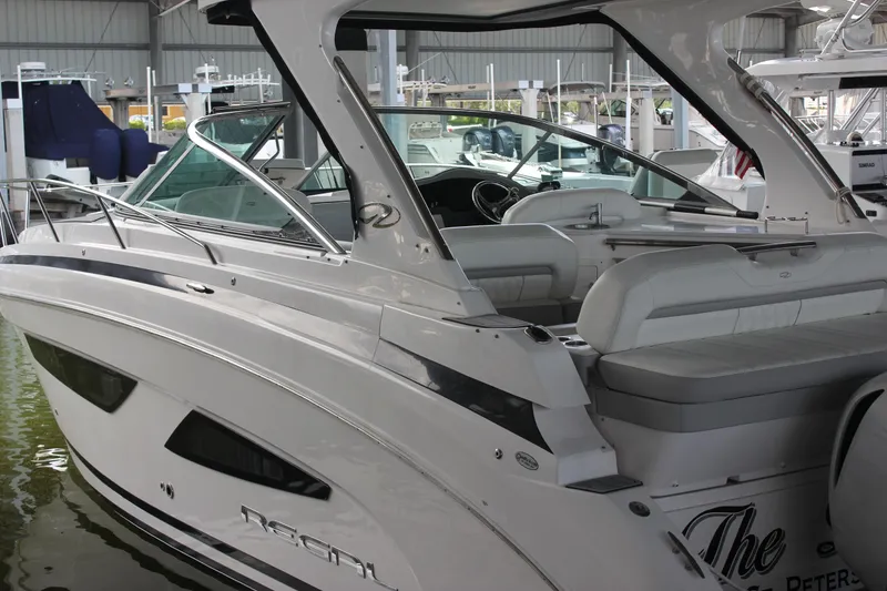 Slide: The Image of 2021 Regal 33 XO boat on water with bridge in background. - 2