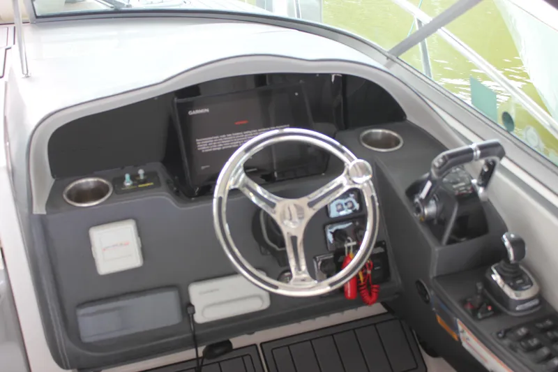 Slide: The Image of 2021 Regal 33 XO boat helm with steering wheel and control panel. - 22