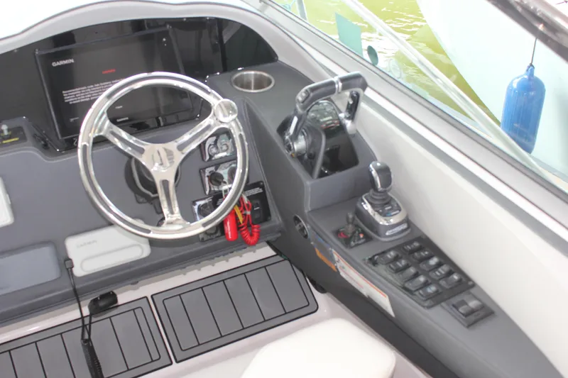 Slide: The Image of 2021 Regal 33 XO boat helm with steering wheel, controls, and navigation equipment. - 23