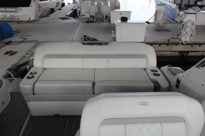 Slide: The Image of 2021 Regal 33 XO boat interior with white seating and cup holders at dock. - 25
