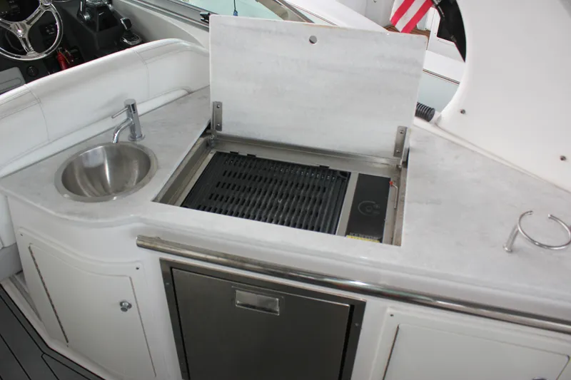 Slide: The Image of 2021 Regal 33 XO boat kitchenette with sink, grill, and storage. - 28