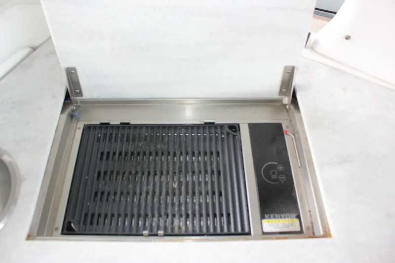 Slide: The Image of Built-in grill on 2021 Regal 33 XO boat, featuring a Kenyon electric cooktop. - 29
