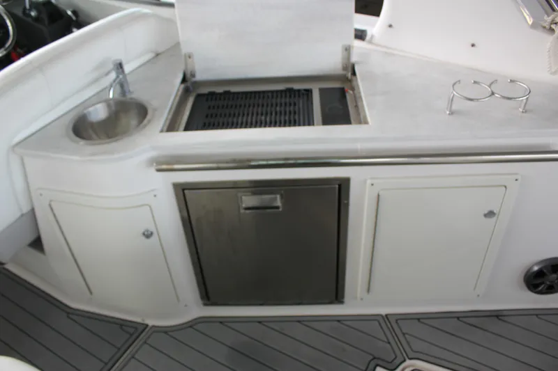 Slide: The Image of 2021 Regal 33 XO boat kitchenette with sink, grill, and storage cabinets. - 30