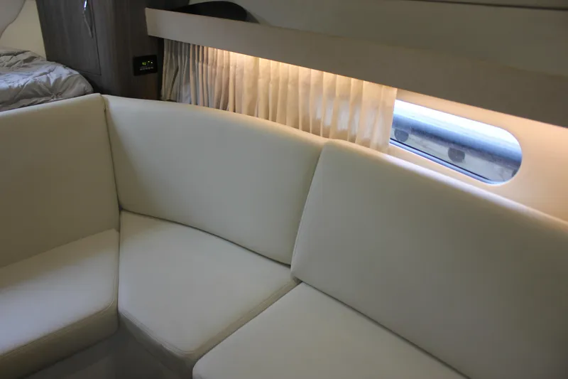 Slide: The Image of Interior of 2021 Regal 33 XO yacht with white seating and window view. - 39