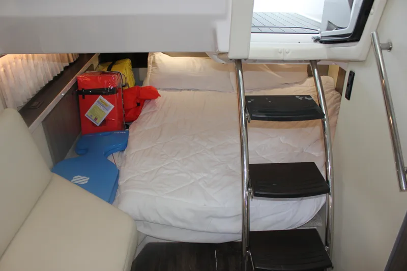 Slide: The Image of 2021 Regal 33 XO cabin interior with bed, ladder, and life jackets. - 42