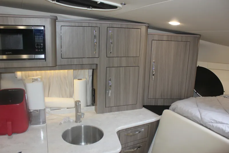 Slide: The Image of 2021 Regal 33 XO yacht interior with modern kitchen and cozy sleeping area. - 45