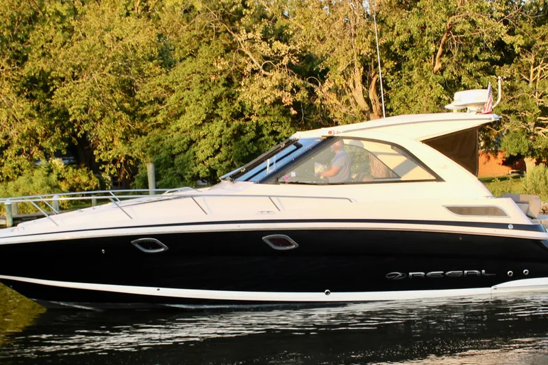Slide: The Image of 2015 Regal 35 Sport Coupe cruising on a serene waterway with lush greenery. - 18