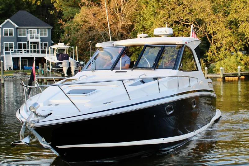 Slide: The Image of 2015 Regal 35 Sport Coupe cruising on a serene lake near waterfront homes. - 20