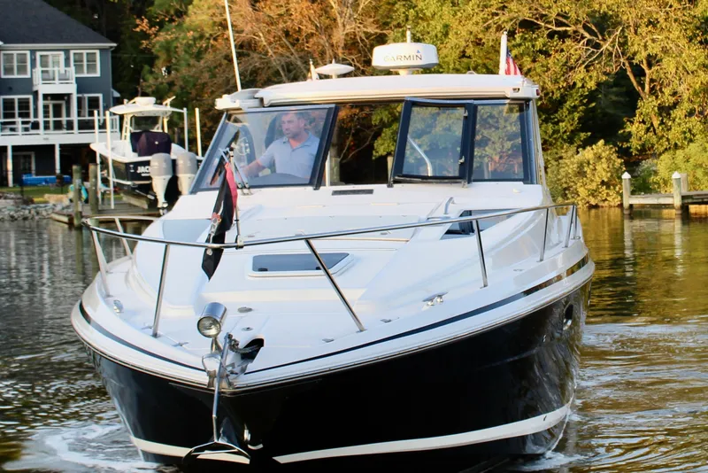Slide: The Image of 2015 Regal 35 Sport Coupe cruising on a calm river near a dock. - 21