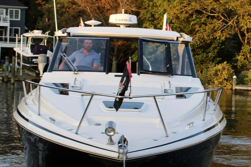 Slide: The Image of 2015 Regal 35 Sport Coupe boat cruising on a calm waterway. - 22