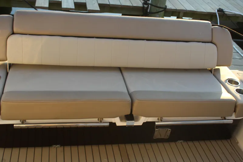 Slide: The Image of 2015 Regal 35 Sport Coupe boat seating with beige cushions and cup holders. - 25