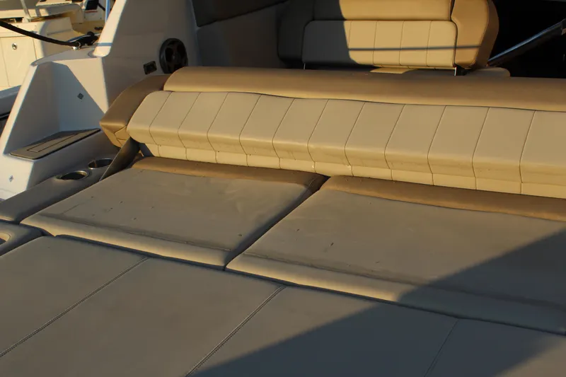 Slide: The Image of Beige seating area on 2015 Regal 35 Sport Coupe boat, featuring cup holders. - 28
