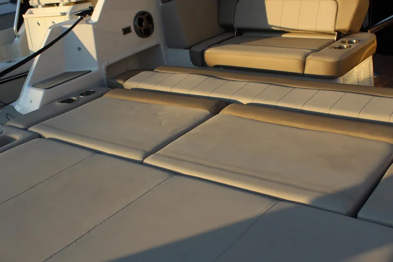 Slide: The Image of Luxurious seating area on a 2015 Regal 35 Sport Coupe boat, featuring beige upholstery. - 29
