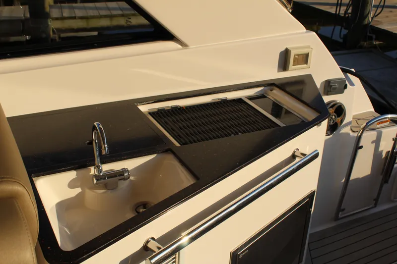Slide: The Image of 2015 Regal 35 Sport Coupe yacht kitchenette with sink and grill on deck. - 32
