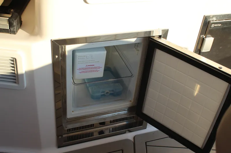 Slide: The Image of Open ice maker compartment on 2015 Regal 35 Sport Coupe boat. - 35