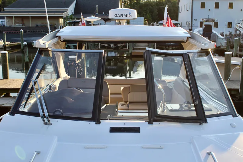 Slide: The Image of 2015 Regal 35 Sport Coupe boat docked at marina, featuring open cockpit and Garmin equipment. - 52