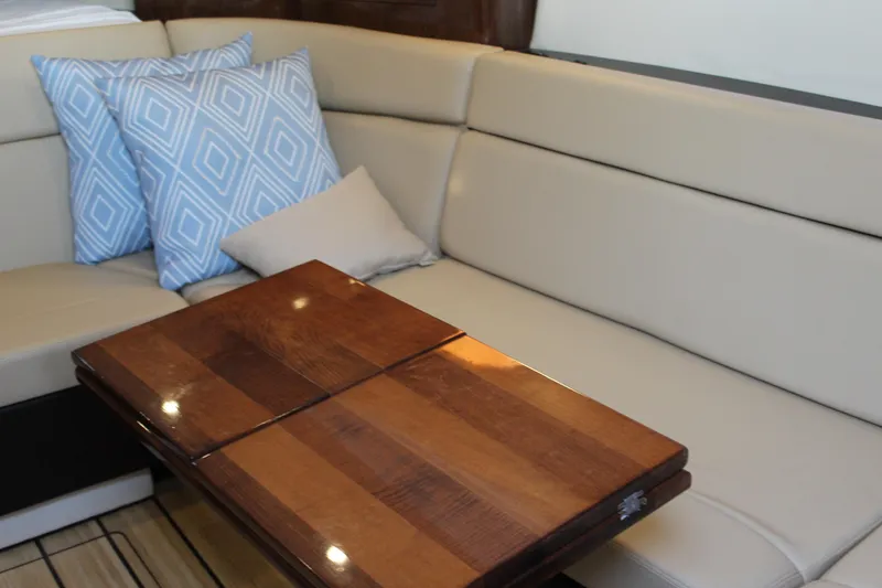 Slide: The Image of 2015 Regal 35 Sport Coupe interior with beige seating, wooden table, and decorative pillows. - 54