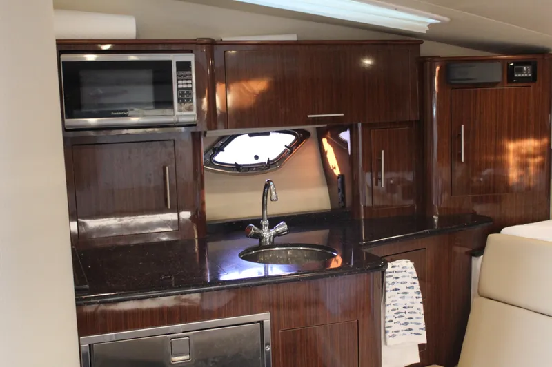 Slide: The Image of Luxurious kitchen interior of 2015 Regal 35 Sport Coupe with wood cabinetry and modern appliances. - 57