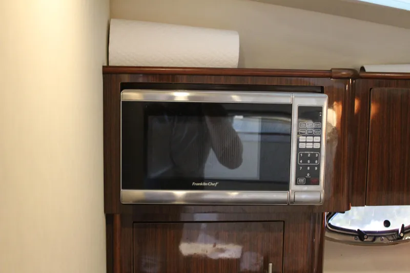 Slide: The Image of Microwave in 2015 Regal 35 Sport Coupe yacht kitchen with wood cabinetry. - 59