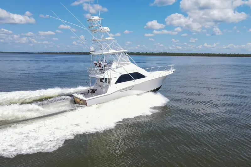 Slide: The Image of 2005 Cabo 40 Flybridge yacht cruising on open water under a clear blue sky. - 1