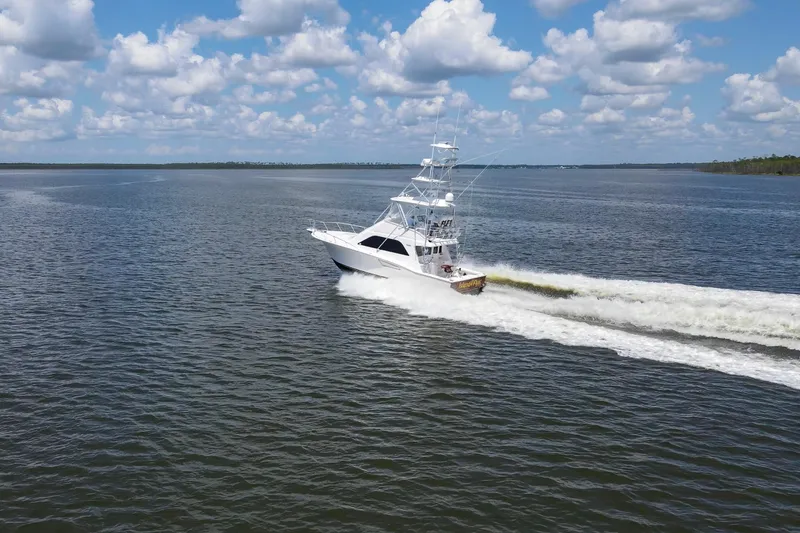Slide: The Image of 2005 Cabo 40 Flybridge yacht cruising on open water under a partly cloudy sky. - 107