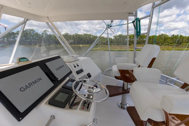 Slide: The Image of Flybridge of 2005 Cabo 40 yacht with Garmin navigation, white seating, and river view. - 11