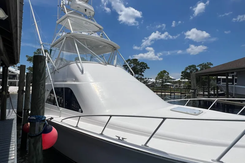 Slide: The Image of 2005 Cabo 40 Flybridge yacht docked under a clear blue sky. - 12
