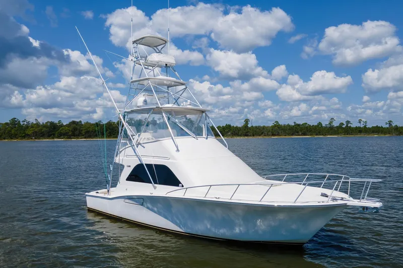 Slide: The Image of 2005 Cabo 40 Flybridge yacht on calm water under a blue sky with clouds. - 2