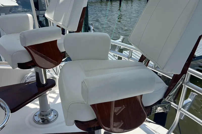 Slide: The Image of Luxurious seating on a 2005 Cabo 40 Flybridge yacht with white cushions and wooden accents. - 21