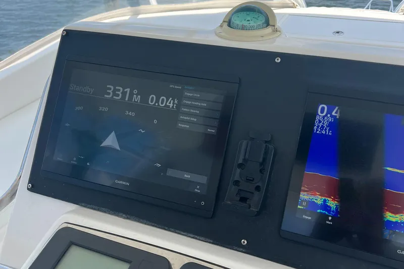 Slide: The Image of Navigation display on 2005 Cabo 40 Flybridge, featuring Garmin screens and compass. - 24