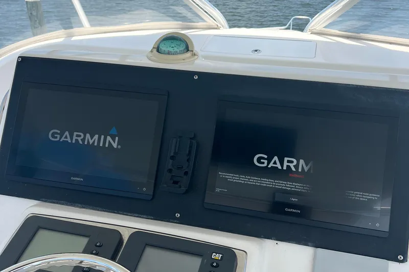 Slide: The Image of Helm of 2005 Cabo 40 Flybridge with dual Garmin navigation screens. - 28