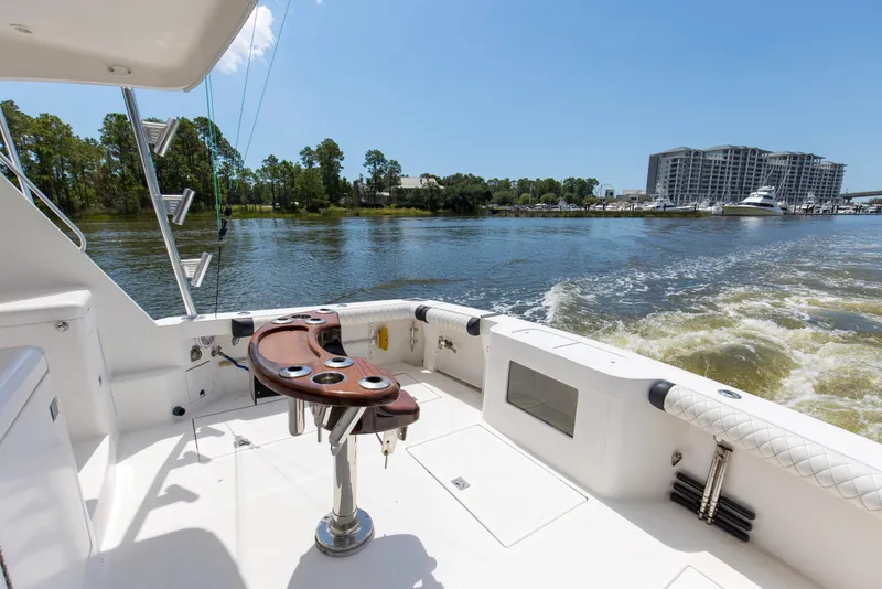 Slide: The Image of 2005 Cabo 40 Flybridge yacht cruising on a sunny day, with scenic waterfront view. - 34