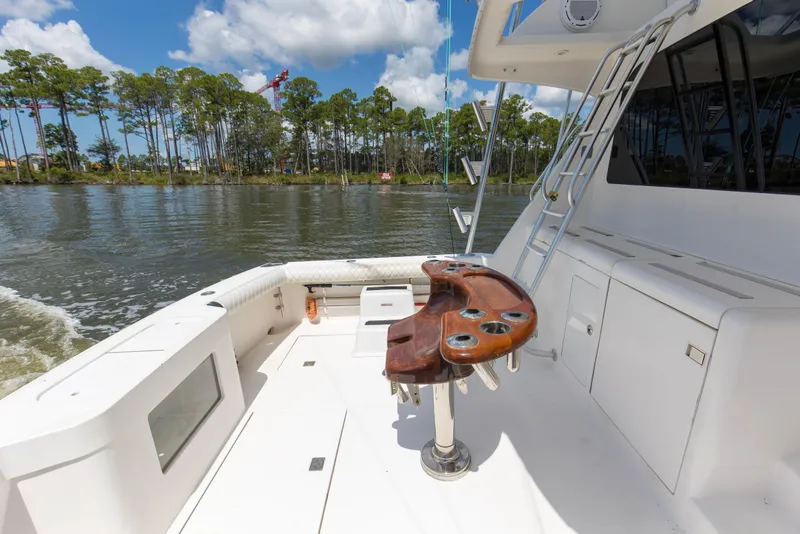 Slide: The Image of 2005 Cabo 40 Flybridge yacht deck with fishing station, ladder, and scenic waterway view. - 37