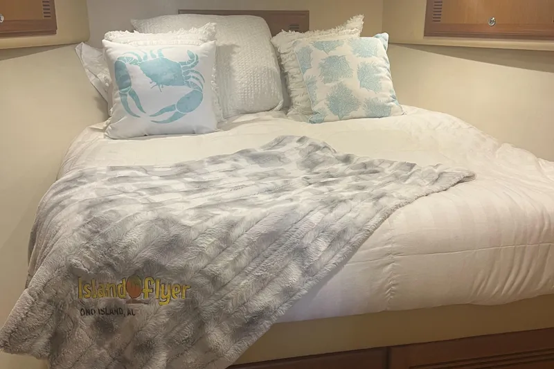 Slide: The Image of Cozy cabin bed in 2005 Cabo 40 Flybridge with nautical-themed pillows and soft blanket. - 39