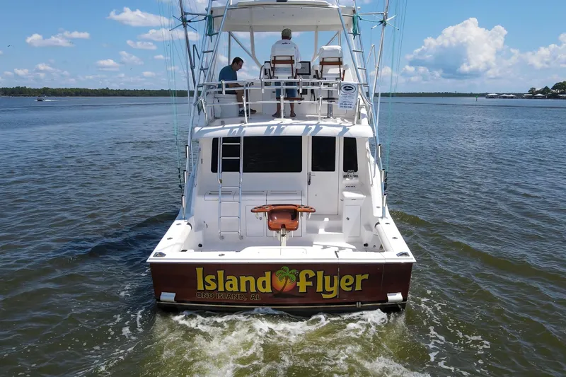 Slide: The Image of 2005 Cabo 40 Flybridge boat named "Island Flyer" on water, rear view. - 4