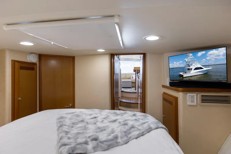 Slide: The Image of Luxurious 2005 Cabo 40 Flybridge yacht interior with cozy bedroom and TV. - 41