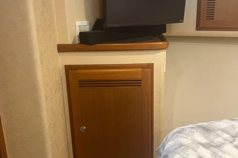 Slide: The Image of Interior of 2005 Cabo 40 Flybridge with wooden cabinet and mounted TV. - 42