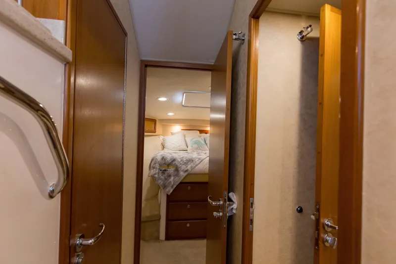 Slide: The Image of Interior of 2005 Cabo 40 Flybridge yacht, featuring cozy bedroom and wooden doors. - 53