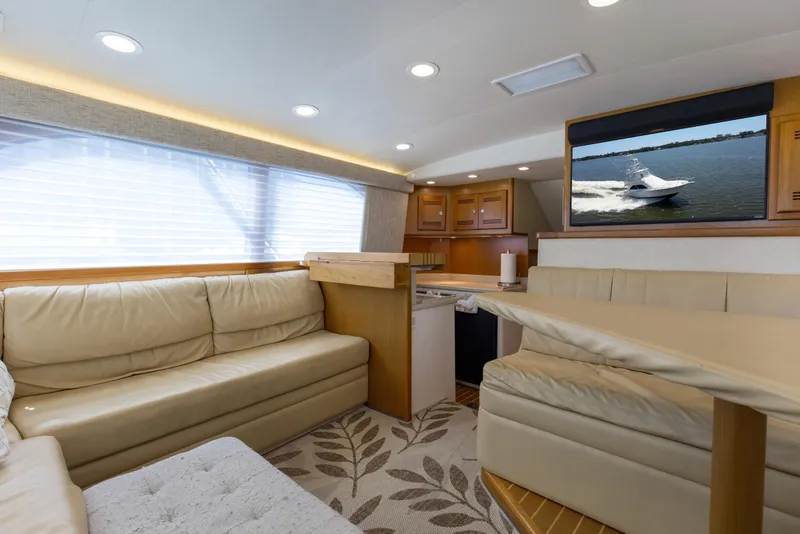 Slide: The Image of Luxurious interior of 2005 Cabo 40 Flybridge yacht with beige seating and modern amenities. - 56