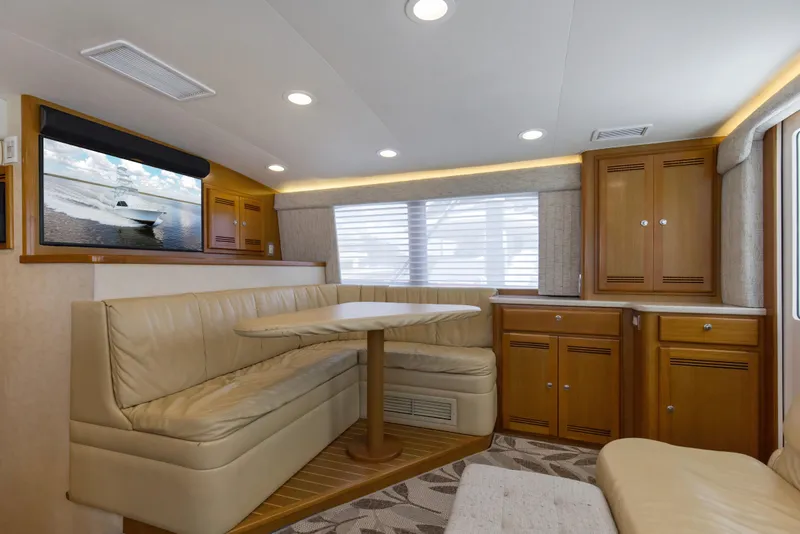 Slide: The Image of Luxurious interior of 2005 Cabo 40 Flybridge yacht with leather seating and wooden cabinetry. - 57