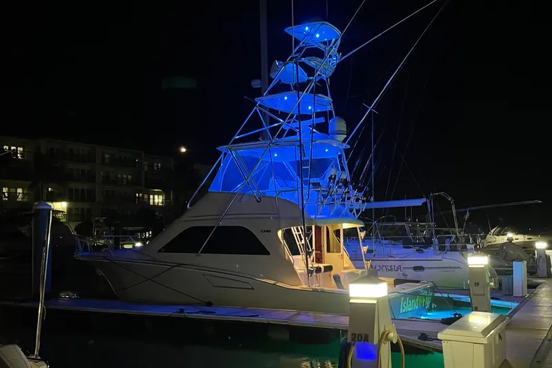 Slide: The Image of 2005 Cabo 40 Flybridge yacht illuminated at night in marina. - 6