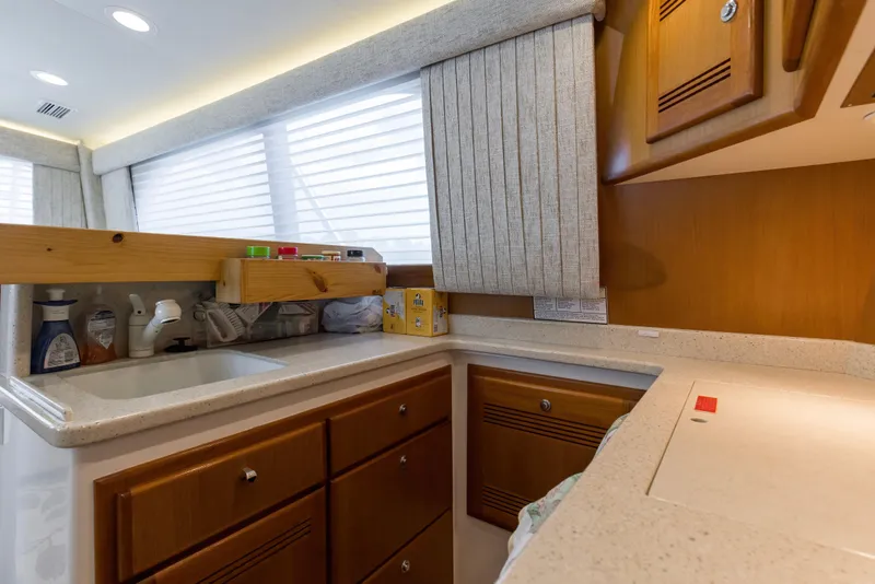 Slide: The Image of 2005 Cabo 40 Flybridge yacht kitchen with wooden cabinets and countertop. - 60