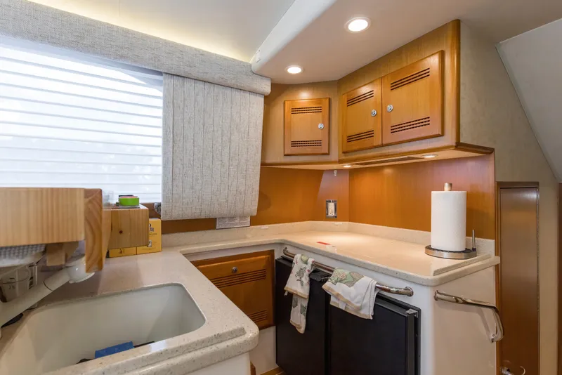 Slide: The Image of 2005 Cabo 40 Flybridge yacht kitchen with wooden cabinets and modern appliances. - 61